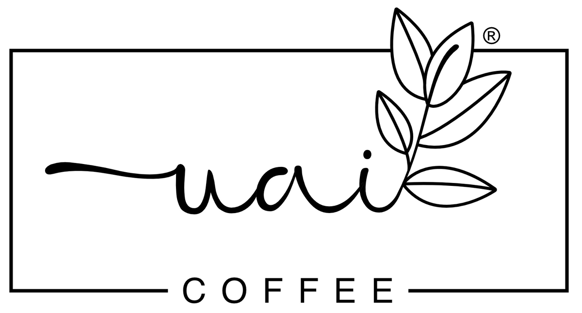 Black and white logo for 'Uai COFFEE' featuring a stylized cursive 'Uai' script, a leaf branch illustration, and the word 'COFFEE' in a clean sans-serif font, all enclosed in a thin rectangular border on a white background.
